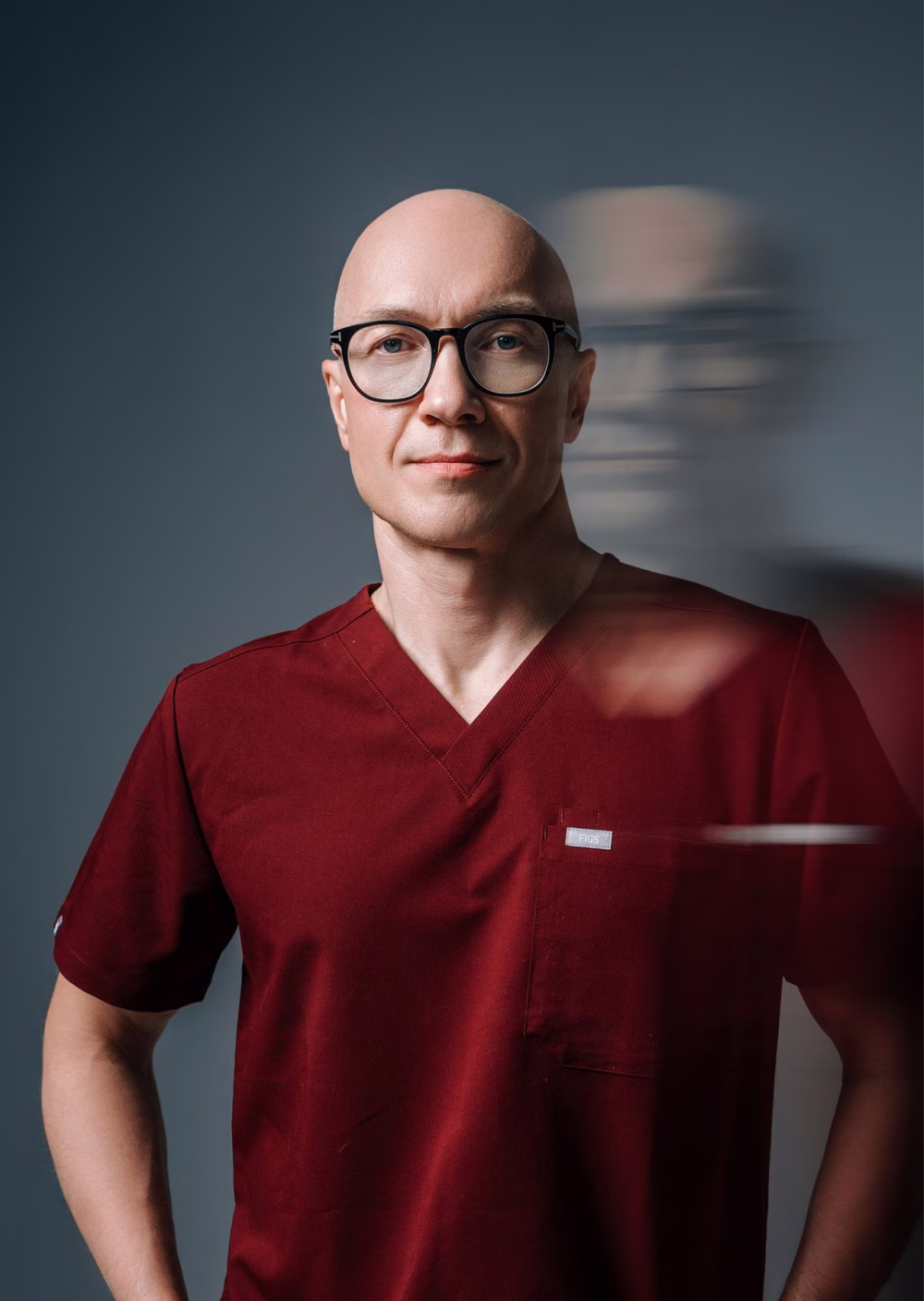 The surgeon in dark red scrubs, caught in motion blur